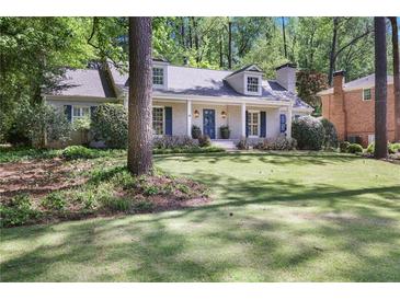 Charming single-story home with a manicured lawn and inviting blue front door at 2567 Hyde Manor Nw Dr, Atlanta, GA 30327