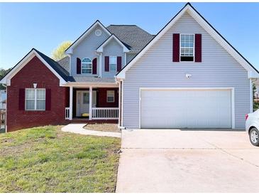 Charming two-story home with brick and siding, attached two car garage, and well-manicured lawn at 385 Bethesda Park Trl, Lawrenceville, GA 30044