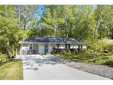 Charming single-story home with a well-manicured lawn and inviting curb appeal, surrounded by mature trees at 4462 Cain Cir, Tucker, GA 30084
