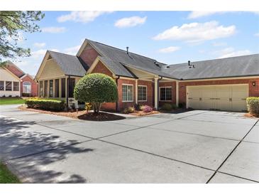 A lovely brick home features a manicured yard and a spacious driveway, perfect for multiple cars at 1304 Brookhavenrun Cir, Duluth, GA 30097