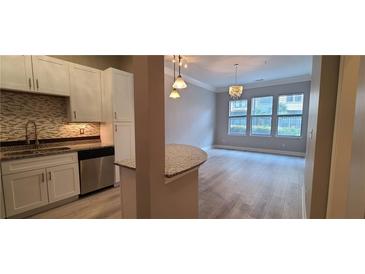Bright kitchen featuring white cabinets, stainless steel appliances, and a mosaic tile backsplash at 400 17Th St # 1114, Atlanta, GA 30318