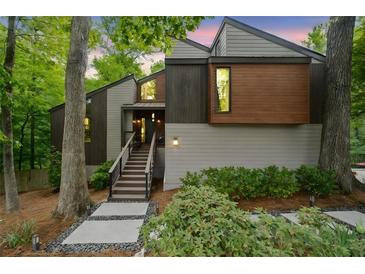 Modern home featuring unique architectural design with wood and gray siding and well-manicured landscaping at 5276 Weatherwood Trce, Marietta, GA 30068