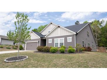 Charming home with gray siding, white trim, a well-manicured lawn, and a two-car garage at 6340 Arlington Cir, Cumming, GA 30041