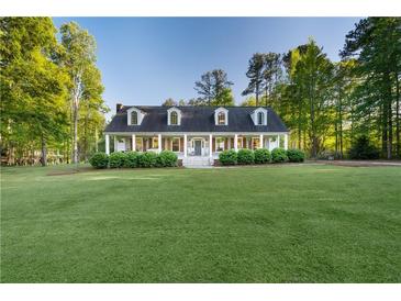 Charming single-Gathering home featuring a manicured front lawn, dormer windows and a large porch at 576 Tope Rd, Sharpsburg, GA 30277