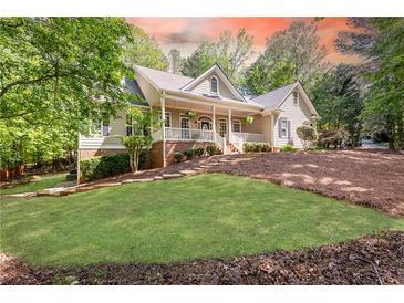 Charming home with a welcoming front porch and beautifully landscaped front yard at 415 Morgan Falls Chase, Canton, GA 30114