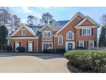 Charming brick home featuring a well-manicured lawn and traditional architectural details at 1594 Stoddard Nw Ct, Kennesaw, GA 30152