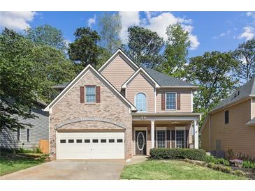 Charming two-story home with a brick front, well-maintained lawn, and a two-car garage at 507 Mirramont Pl, Woodstock, GA 30189