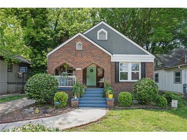 Charming brick home featuring a well-manicured lawn and inviting blue stairs leading to the front porch at 1124 Larosa Sw Ter, Atlanta, GA 30310