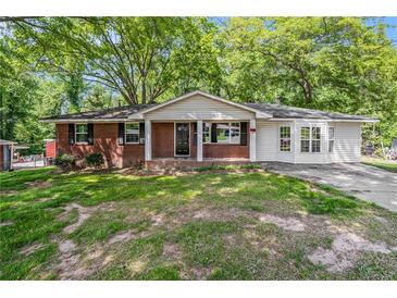 Charming brick and siding home featuring a well-maintained front yard and a cozy front porch at 1132 Luther Sw Dr, Mableton, GA 30126
