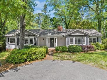 Charming one-story home with a well-manicured lawn, mature trees, and a welcoming front porch at 3150 Rilman Nw Rd, Atlanta, GA 30327