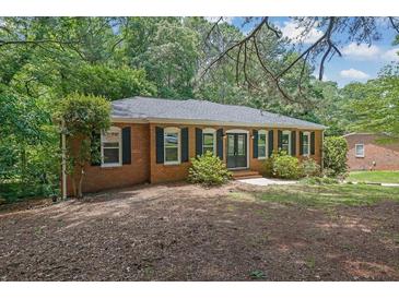 Charming brick ranch-style home featuring a well-maintained lawn and a new roof surrounded by mature trees at 486 Edward Ct, Marietta, GA 30066
