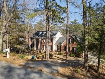 Charming two-story brick home with a columned front porch, surrounded by mature trees at 1480 Niskey Lake Sw Rd, Atlanta, GA 30331
