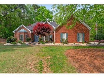 Charming brick home featuring a manicured lawn, landscaped garden, and a classic architectural design at 235 Huiet Dr, Mcdonough, GA 30252