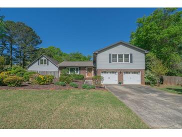 Charming home featuring a well-maintained lawn, mature landscaping, and a two-car garage at 2921 Huntcliff Dr, Marietta, GA 30066