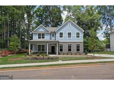 Charming two-story home showcasing light blue siding, brick accents, and a well-manicured front yard at 4549 Ajo Lot#30 Walk, Atlanta, GA 30331