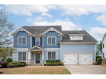 Charming two-story home with a well-manicured lawn, a two-car garage and a welcoming front porch at 520 Tackett Farms Rd, Smyrna, GA 30082