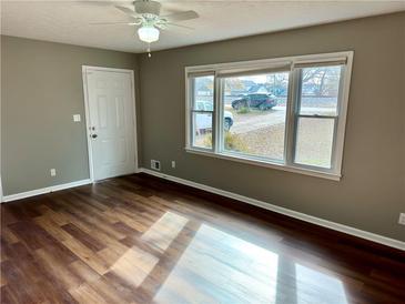 Bright living room featuring wood floors, a large window, and a ceiling fan for comfortable living at 1277 4Th Ave, Auburn, GA 30011