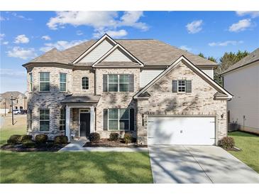 Beautiful two-story home featuring a brick facade, attached garage, and well-manicured front lawn at 3564 Nathan Farm Ln, Buford, GA 30519
