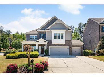 Charming two-story home with brick and siding, showcasing a well-manicured lawn and two-car garage, embodying classic suburban appeal at 1862 Lake Ebenezer Trl, Marietta, GA 30066