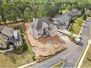 Spacious home construction with an unfinished yard, showcasing the neighborhood and lush surrounding greenery at 5694 Brendlynn Dr, Suwanee, GA 30024