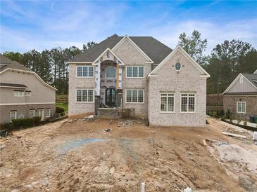Stunning two-story brick home with an elegant design and spacious front yard with unfinished landscaping at 5694 Brendlynn Dr, Suwanee, GA 30024