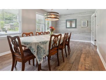 Bright dining room with wood floors, stylish light fixture, and a large window at 3925 Chicamauga Ne Dr, Kennesaw, GA 30144