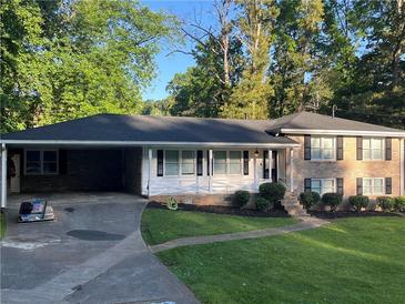 Charming single-Gathering home featuring brick and siding, a lush lawn, and a covered carport at 3925 Chicamauga Ne Dr, Kennesaw, GA 30144