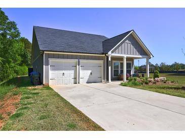 Charming single-Gathering home with a two-car garage, covered porch, and well-manicured lawn at 1014 Starmoss Ln, Conyers, GA 30094