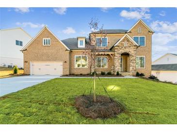 Charming brick home features a stone accent facade, manicured lawn, and attached two-car garage at 2019 Fern Mountain Ln, Marietta, GA 30064
