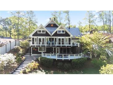 Charming lake house with a large deck, stone accents, and lush landscaping at 6255 Lakeview Dr, Buford, GA 30518