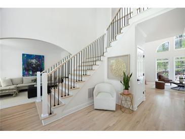 Bright foyer with a modern staircase and views into the living room, featuring light hardwood floors and tasteful decor at 648 Gold Valley Pass, Canton, GA 30114