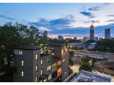 Beautiful brick home with a rooftop deck overlooking the city skyline at twilight at 631 Boulevard Ne, Atlanta, GA 30308