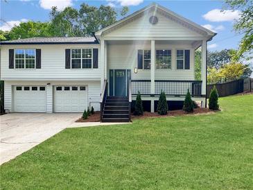 Charming home with a manicured lawn, covered porch, and a two-car garage with beautiful modern curb appeal at 319 Primrose Ln, Auburn, GA 30011