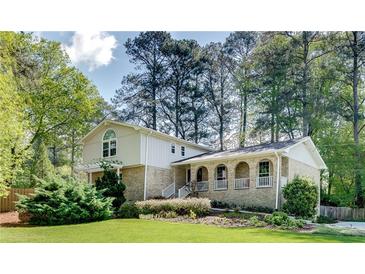Charming two-story brick home with a well-manicured lawn and mature trees at 1631 Manhasset Dr, Atlanta, GA 30338