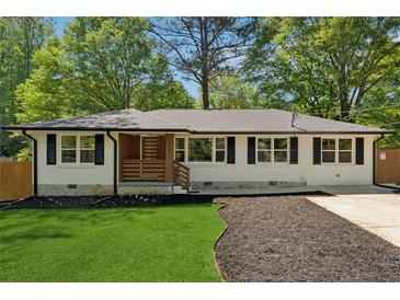 Charming white-brick home featuring black shutters and a well-manicured front yard with dark mulch at 1737 Briarlake Cir, Decatur, GA 30033