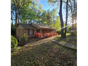 Charming single story home with brick facade, mature landscaping, and welcoming walkway leading to the entrance at 1901 Arnold Dr, Austell, GA 30106