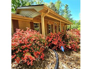 Charming brick home featuring colorful azaleas, manicured lawn, and a welcoming entrance at 1901 Arnold Dr, Austell, GA 30106