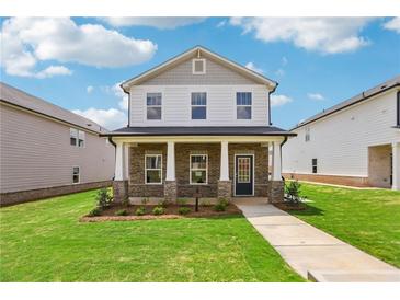 Charming two-story home featuring stone accents, a covered front porch, and a well-maintained lawn at 1290 Firefly Field Trce, Lawrenceville, GA 30045