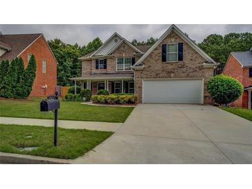 Charming two-story brick home featuring a well-manicured lawn, a two-car garage, and traditional architectural details at 1670 Cooper Lakes Dr, Grayson, GA 30017