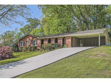 Charming brick home with a covered carport and a long driveway at 751 Oneta Dr, Norcross, GA 30093