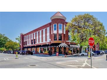 This building features a red brick exterior with black awnings and is located on a tree-lined street at 1133 Church St # 6, Covington, GA 30014