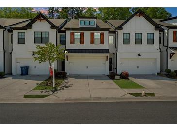 Charming townhouse showcasing modern farmhouse design with brickwork, black trim, and a two-car garage at 125 Auburn Gate Ln, Auburn, GA 30011