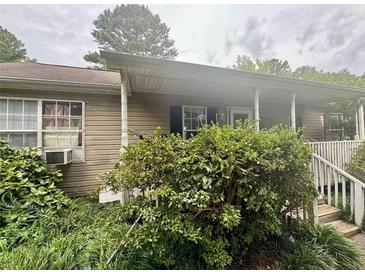 Modest home exterior with vinyl siding, covered porch, and landscaped yard at 177 New Hope Cir, Fayetteville, GA 30214