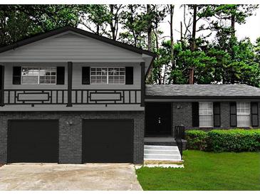 Charming two-story home featuring an attached garage and inviting front yard, all painted in neutral gray tones at 2302 Aurie Dr, Decatur, GA 30034
