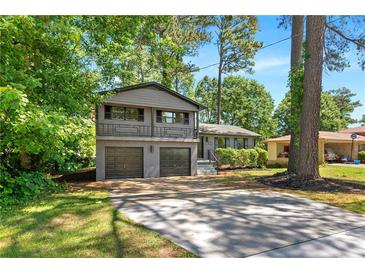 Charming two-story home featuring a gray brick facade, two-car garage, and well-maintained lawn at 2302 Aurie Dr, Decatur, GA 30034