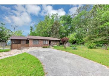 Charming single story brick home with a spacious driveway and well manicured lawn at 9186 Puckett St, Covington, GA 30014