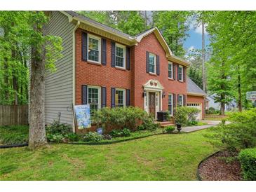 Charming two-story brick home with black shutters and a well-manicured front lawn at 1520 N Milford Creek Sw Ln, Marietta, GA 30008