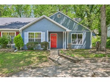 Charming blue home features a bright red front door, large window, and well-maintained lawn at 5126 Farm Place Ne Dr, Woodstock, GA 30188