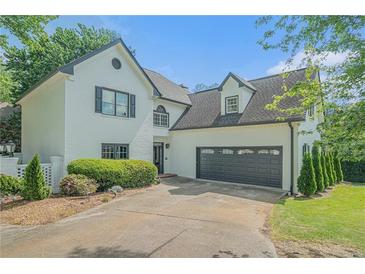 Charming two-story home with a white painted brick exterior, landscaped yard, and an attached two car garage at 1751 Bergen Ct, Lawrenceville, GA 30043