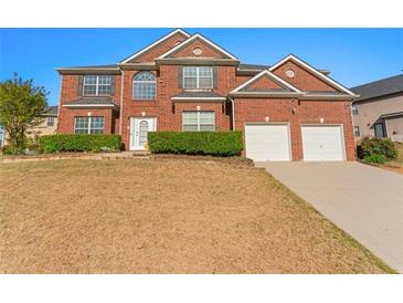 Inviting brick two-story home featuring a two-car garage and well-maintained landscaping at 3971 Busby Mill Ct, Ellenwood, GA 30294